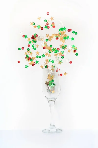 I coriandoli variopinti in forma di stelle hanno versato occhiali di champagne su bianco. Vista dall'alto. Festa di Natale. Notte magica . — Foto Stock