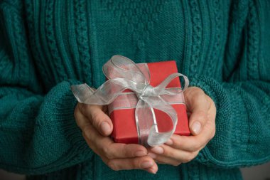 Christmas kırmızı giftbox gümüş kurdele ile tutarak el. Tatil. Boxing günü.