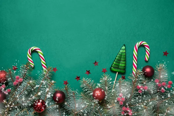 크리스마스 나무 가지, 사탕 지팡이 녹색 배경 복사 공간에 빨간 유리 공. 최고의 볼 수 있습니다. 크리스마스 카드. — 스톡 사진
