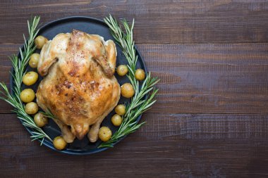Kızartma tavuk patates ve ahşap masa üzerinde Rosemary ile. Kopya alanı.