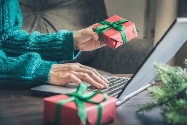 Noel zamanı. Giftbox tutarak ve ev iç içinde laptop kriteri kadın. Xmas kavramı.
