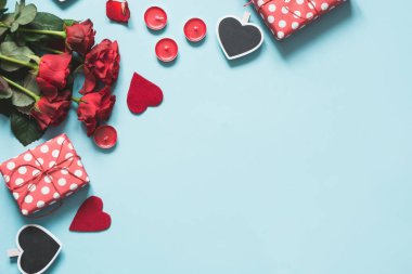 Sevgililer günü kartı. Hediyeler, kırmızı kalpler mavi yüzeyi ile kompozisyon. Üstten görünüm. Metin için yer.