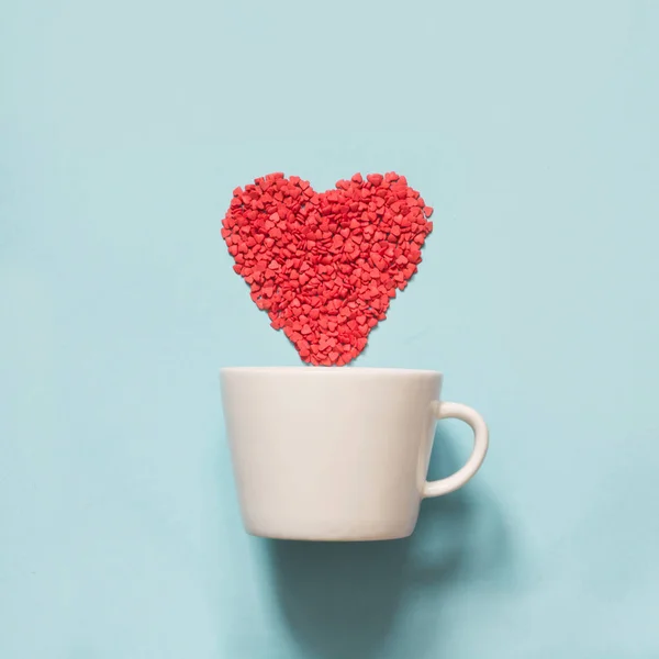 Valentine's card. Creative heart of red confetti in cup. Top view. Flat lay.