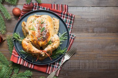 Geleneksel Noel tavuk baharat ve ahşap masa üzerinde biberiye ile kavrulmuş. Üstten görünüm.
