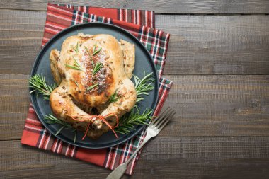 Geleneksel Noel tavuk baharat ve ahşap masa üzerinde biberiye ile kavrulmuş. Üstten görünüm.