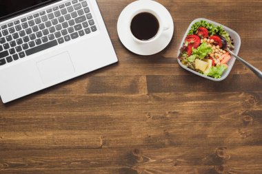 Sağlıklı bir iş ofis, salata, ahşap masa kahve öğle yemeği. Üstten görünüm kopya alanı ile. Kavram sağlıklı beslenme. Beslenme çantası.
