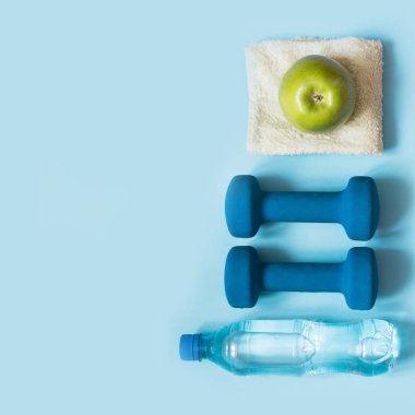 Spor donatımı. Mavi arka plan kopya alanı ile spor ve fitness ekipmanları yaratıcı düz yatıyordu. Üstten Görünüm.