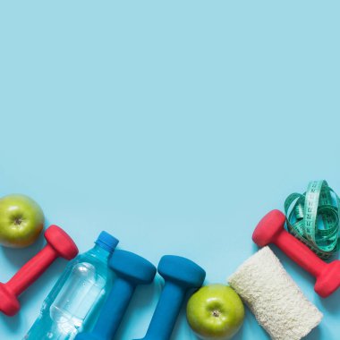 Spor donatımı. Mavi arka plan kopya alanı ile spor ve fitness ekipmanları yaratıcı düz lay.