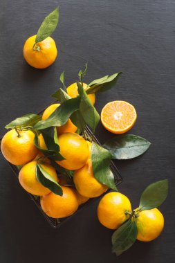 Taze mandalina yaprakları siyah ile. Sağlıklı beslenme kavramı. Uzay kopyalayın. Üstten görünüm.