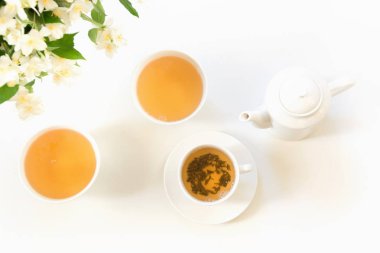 Jasmin yeşil çay ve Yasemin çiçek, beyaz zemin üzerine yeşil çay. Üstten görünüm ve kavram. Çay saati. Kopya alanı.