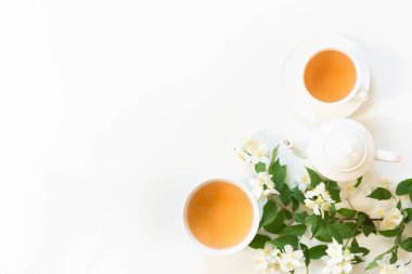 Jasmin yeşil çay ve Yasemin çiçek, beyaz zemin üzerine yeşil çay. Üstten görünüm ve kavram. Çay saati. Kopya alanı.