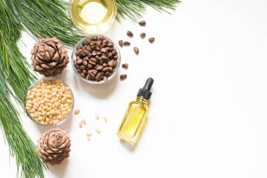 Cedar oil, branches and cedar cone on white background. Copy space. Beauty and healthy concept. clipart