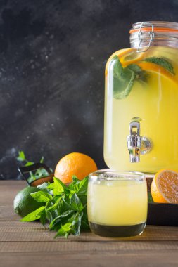 Yaz sağlıklı detoks içeceği. Portakal, limon ve nane siyah ve ahşap tahta üzerinde mason kavanoza ile limonata. Kopya alanı.