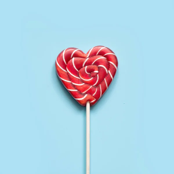 Valentine\'s card. Lollipops candy as heart on blue background. Funny concept.