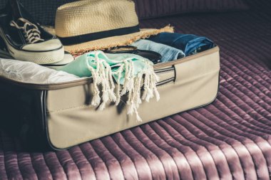 Açık bavul yatak gezi tatil için kadın giysileri ile. Ambalaj şeyler.