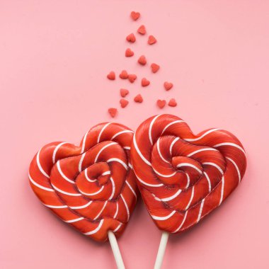 Sevgililer günü kartı. İki lolipop şeker pembe bir arka plan üzerinde kalp olarak. Komik kavramı.