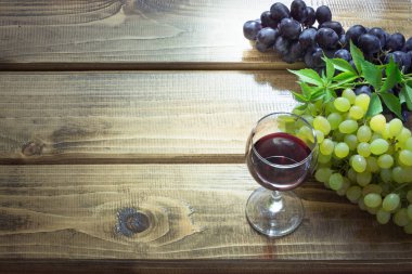 Bardağı kırmızı şarap ve ahşap masa Olgun üzüm. Kadar yakın ve alanı Kopyala.