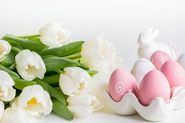 Paskalya kavramı. Beyaz Laleler, renkli yumurta yuva beyaza. Metin için yer.
