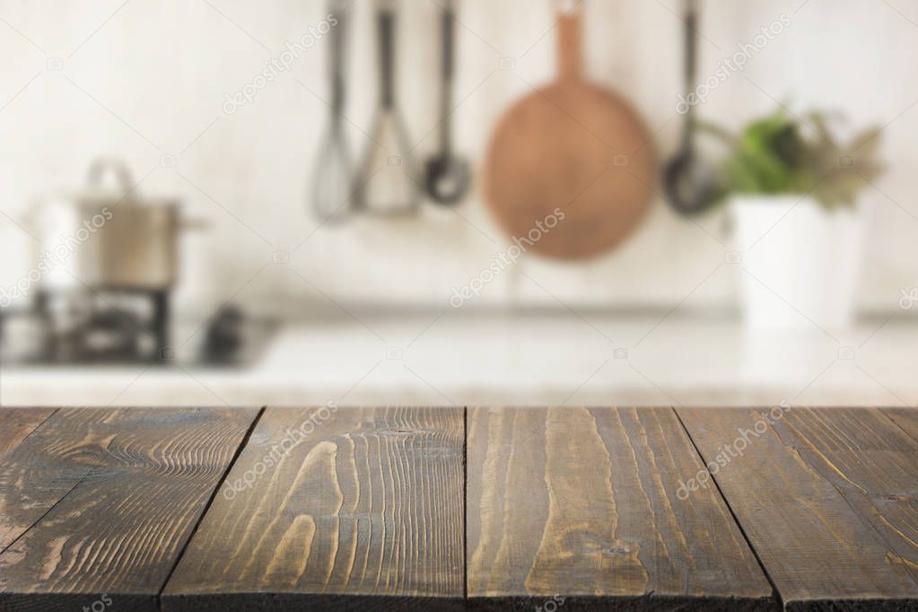 Blurred abstract background. Modern kitchen with wooden tabletop, space for you and display products.