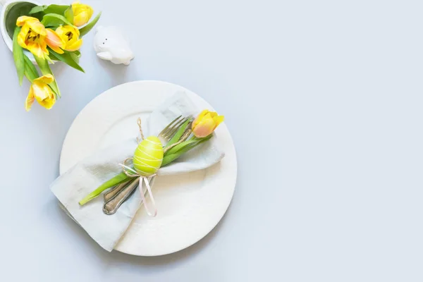 Cena de Pascua. Ajuste de mesa con tulipán amarillo en la mesa. Top vie — Foto de Stock