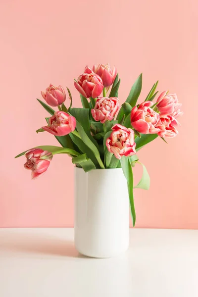 Kytice z červený Tulipán v váza na tisícileté růžová. — Stock fotografie