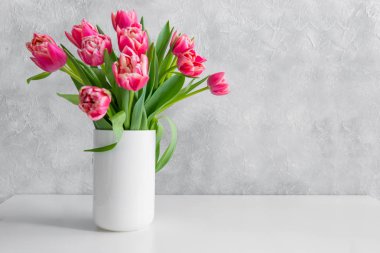 Beyaz vintage tablo vazoda kırmızı lale buketi.