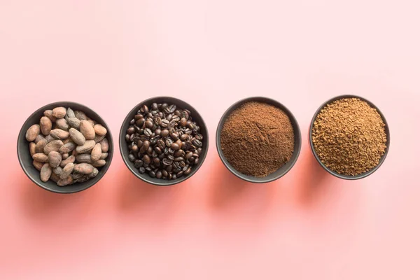 Concepto de cacao y granos de café en cuencos sobre fondo rosa . —  Fotos de Stock