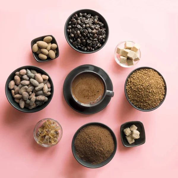 Concept of coffee, cacao beans and sugar on pink background.