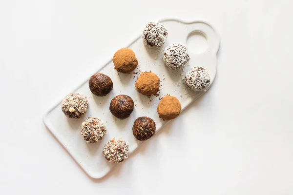 Bolas de energía caseras con cacao y nueces en blanco. Alimento saludable para niños, sustituto de dulces . — Foto de Stock