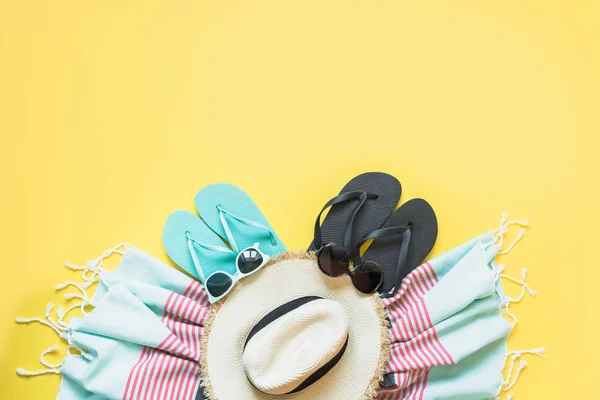 Outfit für Strand- und Tropenurlaub, Sonnenhut aus Stroh, Handtuch, Sonnenbrille auf gelb. Sommerkonzept. — Stockfoto