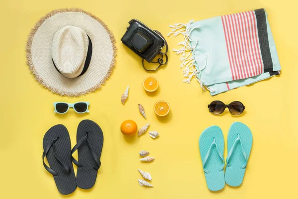 Beach accessories for two, straw beach sunhat,towel, sun glasses on yellow. Summer concept and tropical vacations. — Stock Photo, Image