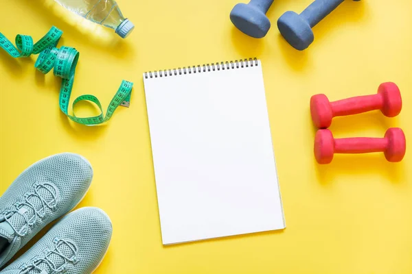 Equipamiento deportivo y de fitness, mancuernas, zapatos de fitness, cinta métrica en amarillo punzante . — Foto de Stock