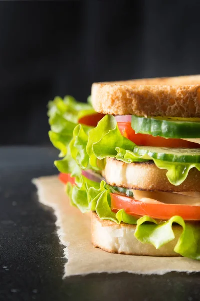 Sandwich with bacon,tomato, onion, salad on black. Close up. — Stock Photo, Image