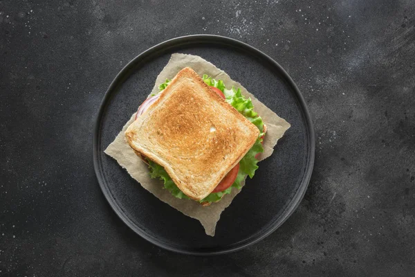 Sandwich with bacon, tomato, onion, salad on black background. Isolated. View from above. — Stock Photo, Image