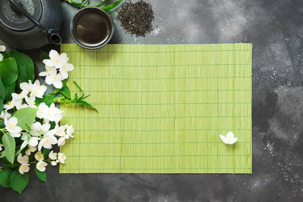 Zöld Jasmin tea és jázmin virágok, csésze zöld tea fekete. Felülnézet. Teatime. — Stock Fotó