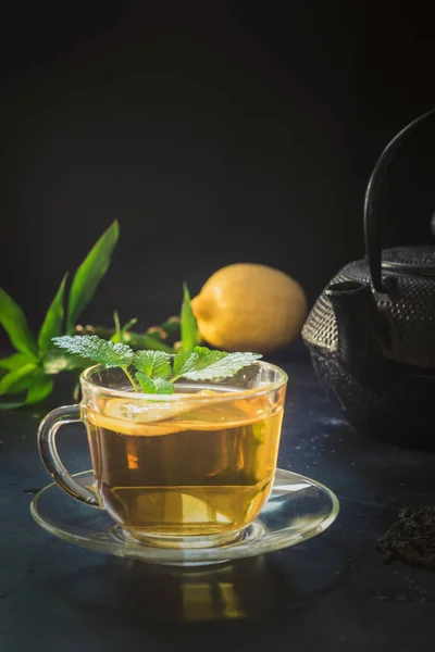 Csésze teát, citromfű és fekete teáskanna sötét. Kínai tea koncepció. — Stock Fotó