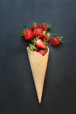 Siyah üzerinde dondurma koni lezzetli olgun organik çilek.