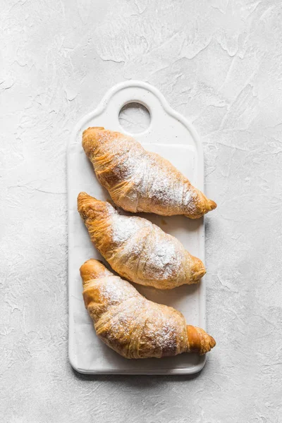 Fresh homemade croissants on baking tray with baking paper. French bakery concept. — Stock Photo, Image
