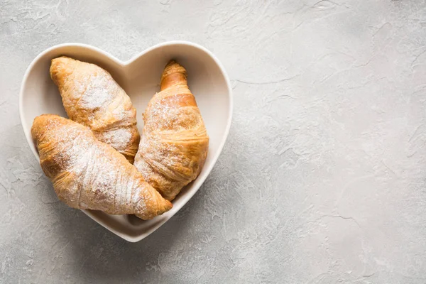 Freshly baked croissants on gray background. Top view. Copy space. — Stock Photo, Image