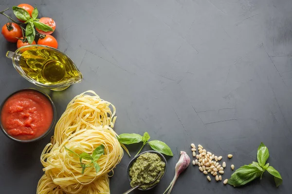 Tésztaösszetevők az olasz ételek, tagliatelle, paradicsom, bazsalikom, olaj és fokhagyma főzéshez. — Stock Fotó