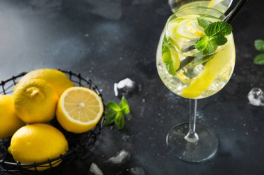 Mojito kokteyl veya limonata ile limonata kireç ve siyah masada cam nane. Yakından kapatın. Yaz içkisi.