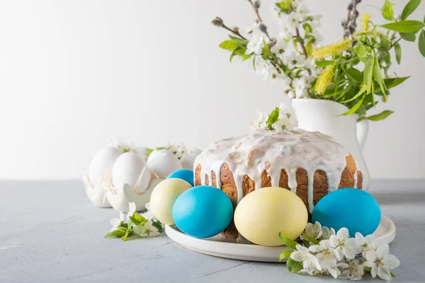 Пасхальный торт, цветные яйца на семейном столе с цветами вишни. Пространство для текста . — стоковое фото