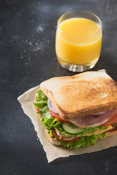Sandwich with bacon,tomato, onion, salad on black. Close up. — Stock Photo, Image