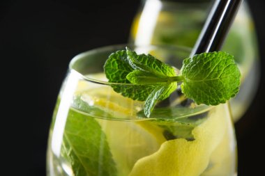 Mojito kokteyl veya limonata ile limonata kireç ve siyah masada cam nane. Yakından kapatın. Yaz içkisi.
