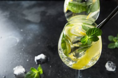 Mojito kokteyl veya limonata ile limonata kireç ve siyah masada cam nane. Yakından kapatın. Yaz içkisi.