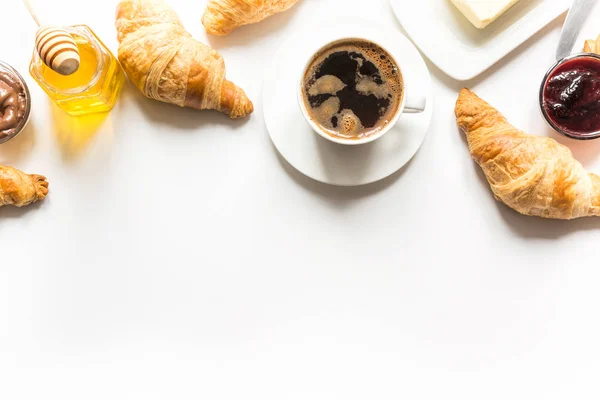French freshly baked croissants and cup of coffee on white . Space for text. — Stock Photo, Image