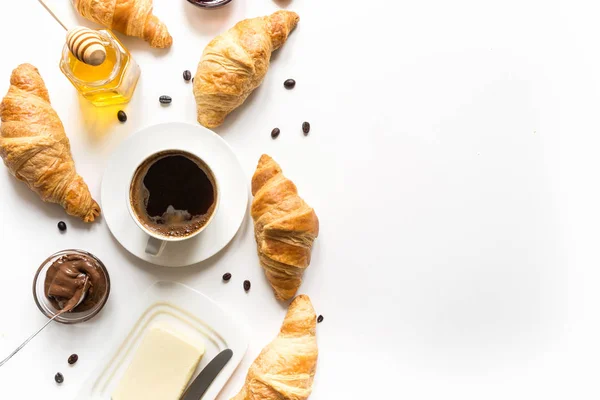 French freshly baked croissants and cup of coffee on white . Space for text. — Stock Photo, Image