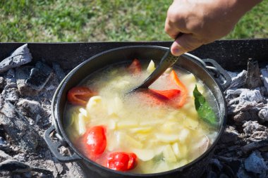 Büyük bir dökme demir kazan açık ta shurpa çorbası pişirme süreci. Türk mutfağı.
