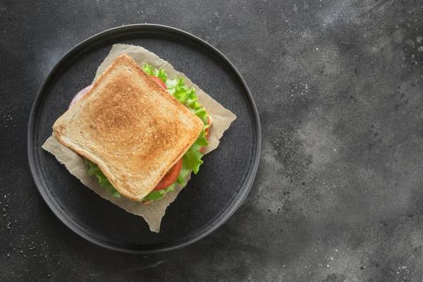 Sandwich with bacon, tomato, onion, salad on black background. Isolated. View from above. — Stock Photo, Image