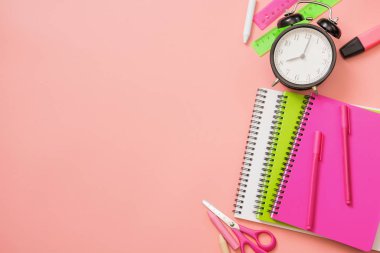 Üzerine pastel pembe renkli okul malzemeleri. Üstten görünüm, düz yatıyordu. Metin için yer.